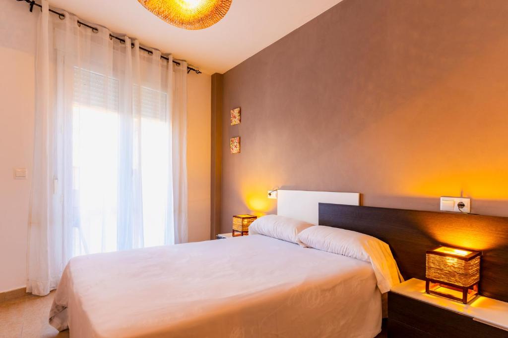 a bedroom with a large bed and a window at Apartamento Confort Valderrobres in Valderrobres