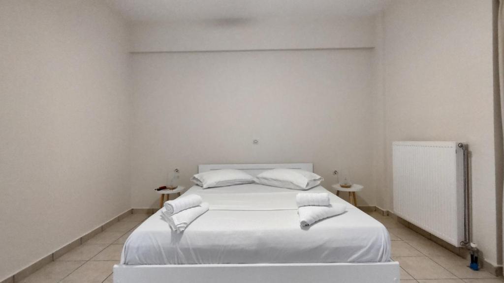 a bedroom with a bed with white sheets and pillows at Messinian Aura in Arkondikó