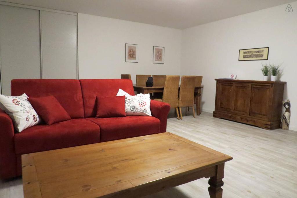 un salon avec un canapé rouge et une table basse dans l'établissement Casa Vacanze Tigli, à Basiglio