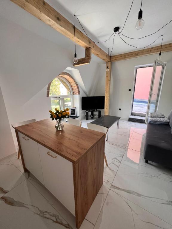 ein Wohnzimmer mit einem Tisch und einem Klavier in der Unterkunft Dworskiego 74, Apartament 2 in Przemyśl