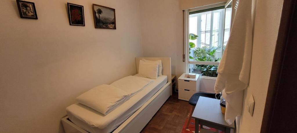 a small room with a bed and a window at Cozy Room near Airport , Metro and Train Station in Lisbon