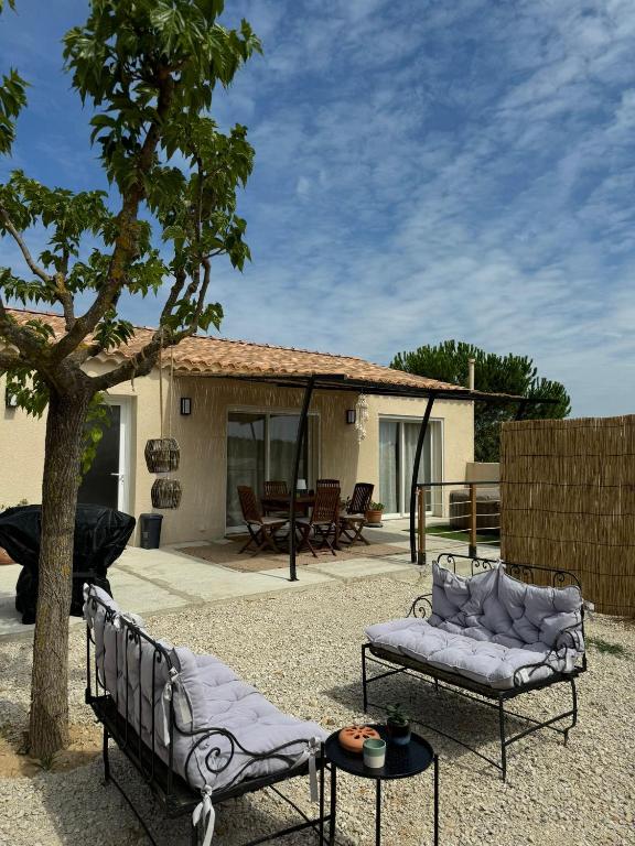 une terrasse avec deux canapés et un arbre dans l'établissement La Farigoule - Villa avec spa, clim, terrasse, à La Roque-sur-Cèze