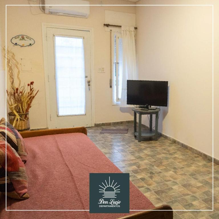 a living room with a bed and a flat screen tv at Don Lucio Departamentos in Carhué