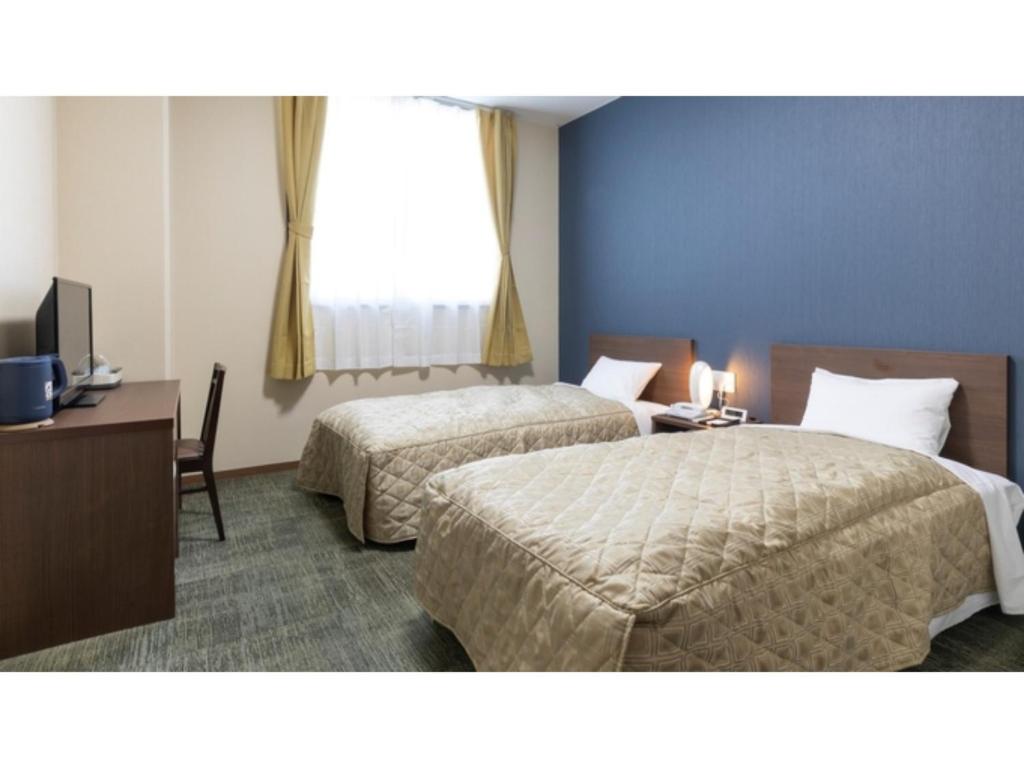 um quarto de hotel com duas camas, uma escrivaninha e uma janela em Hill Hotel Sunpia Iga - Vacation STAY 92291v em Iga