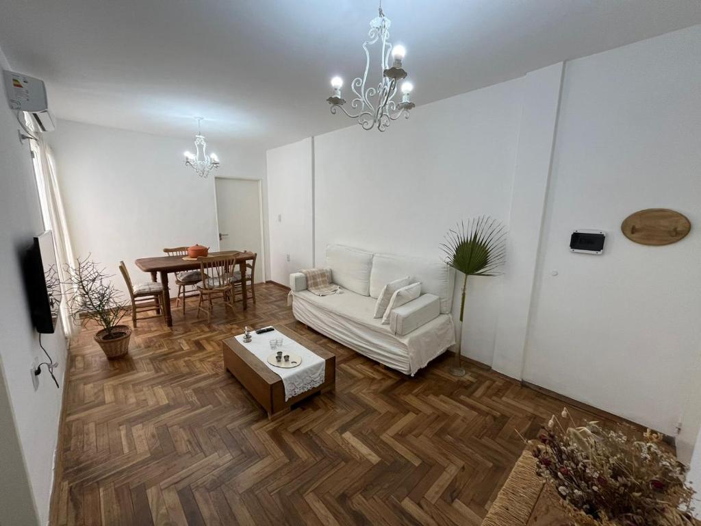 Una sala de estar con un sofá blanco y una mesa. en Departamento FABULOSO en 25 de mayo, en Santa Fe