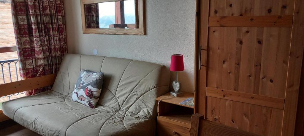 - un canapé dans une chambre avec une lampe sur une table dans l'établissement Résidence Armoise - Studio 3 personnes à Arc 1800 en centre station, proche des pistes et des commerces, dans le village des Villards MAE-1982, à Arc 1800
