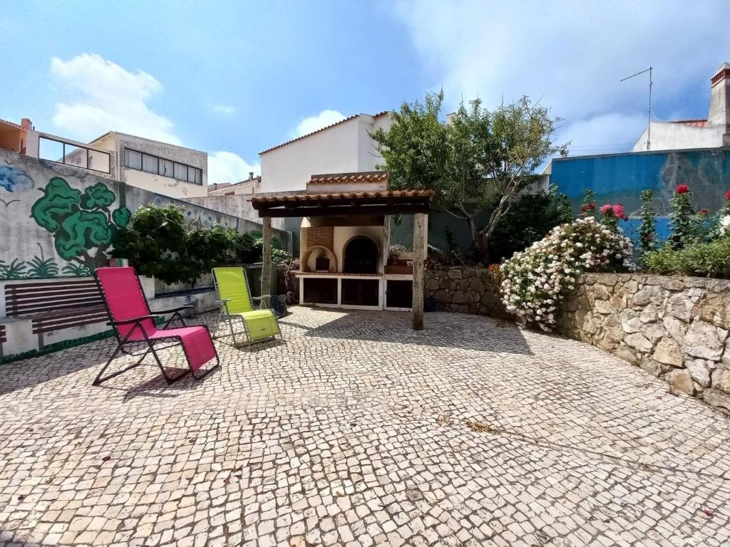 un grupo de sillas sentadas en un patio en Casa do Portão Azul - Dourada, en Atouguia da Baleia