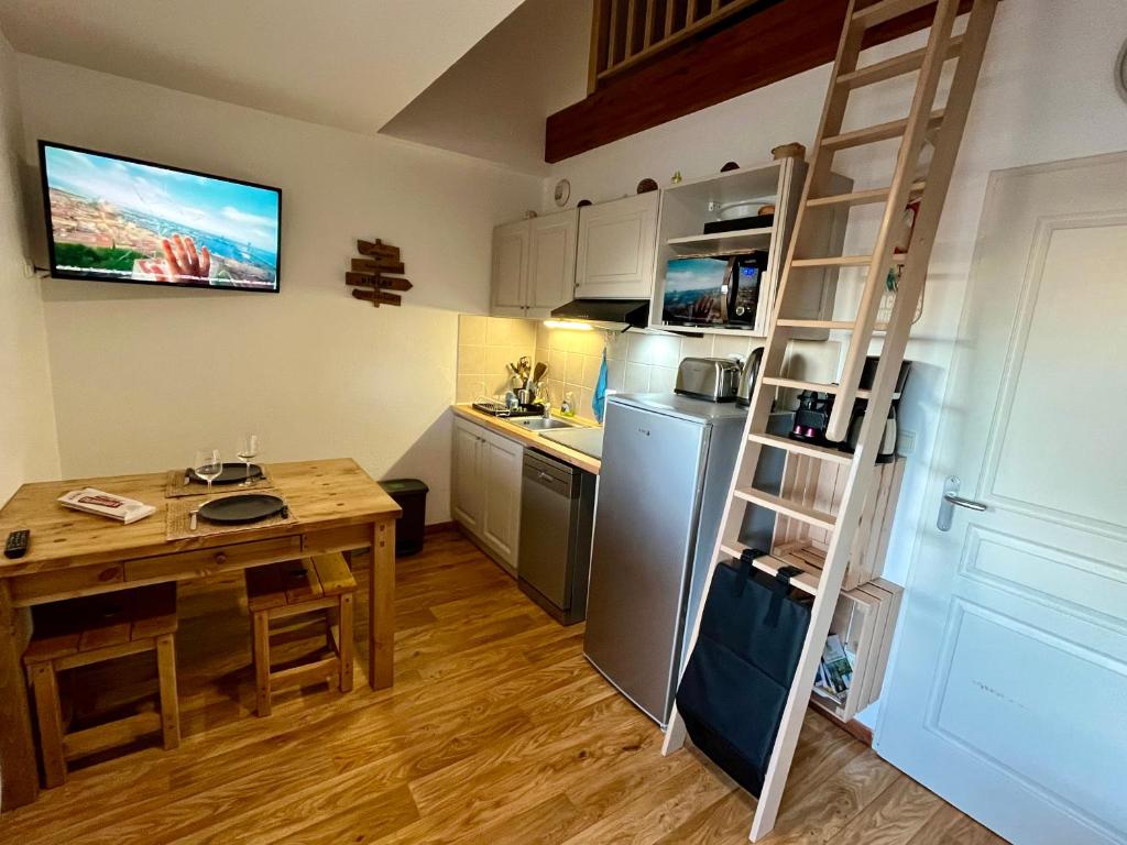 a small kitchen with a table and a refrigerator at Orcières Merlette - Haut Champsaur, classé 3* in Orcières