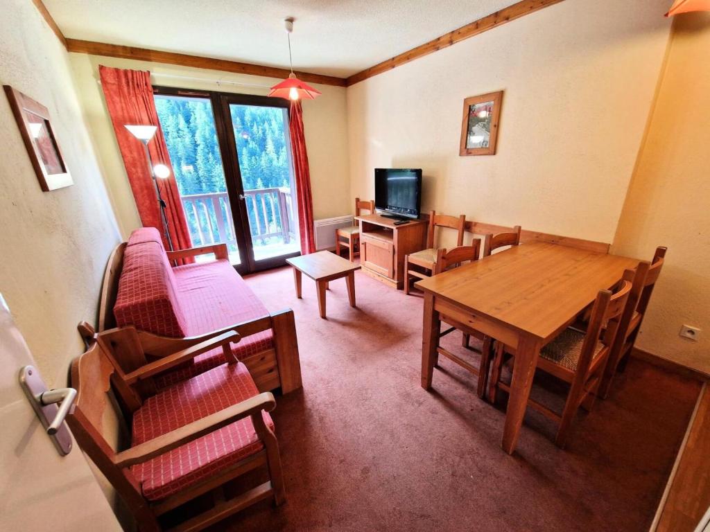 une salle à manger avec une table, des chaises et une télévision dans l'établissement Chalets Du Thabor - 3 pièces 6 personnes dans résidence bien situé MAE-9471, à Modane