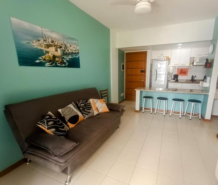 a living room with a couch and a kitchen at Apartamento Solar Rio Vermelho in Salvador