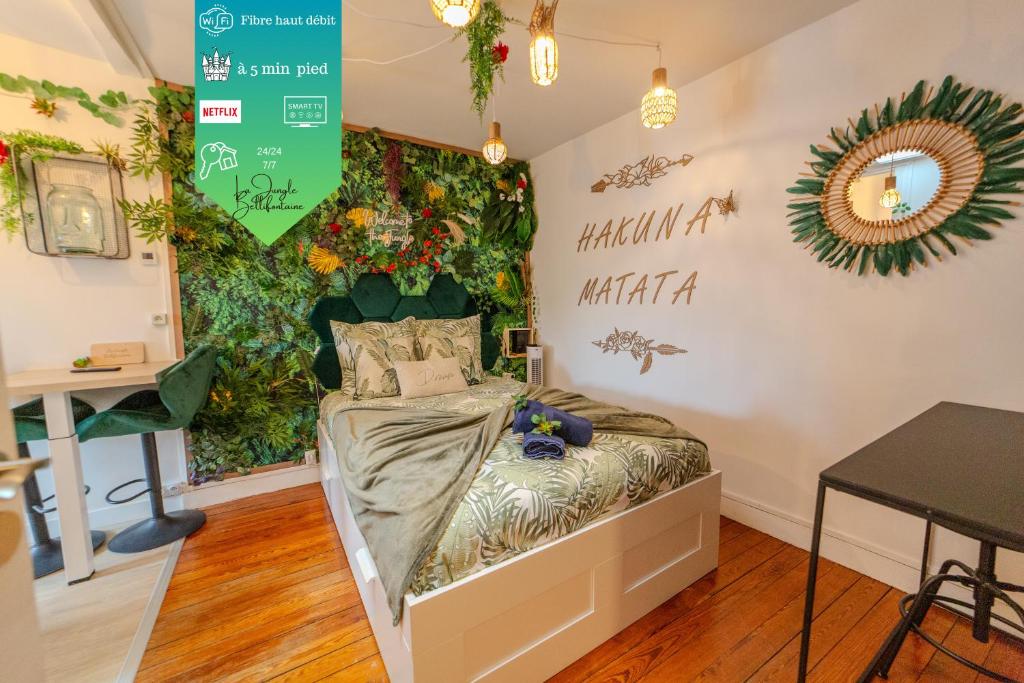 Cette chambre comprend un lit avec un mur vert. dans l'établissement Studio La Jungle bellifontaine, à Fontainebleau