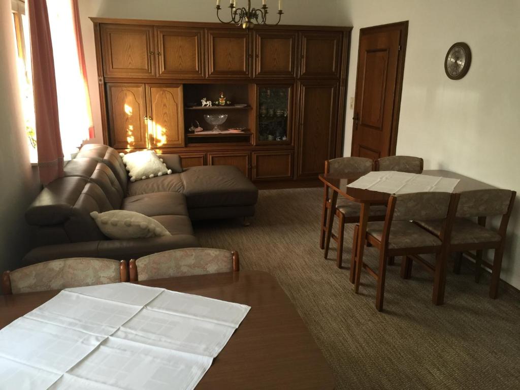 sala de estar con sofá, mesa y sillas en Landhaus Moises, en Bad Hofgastein