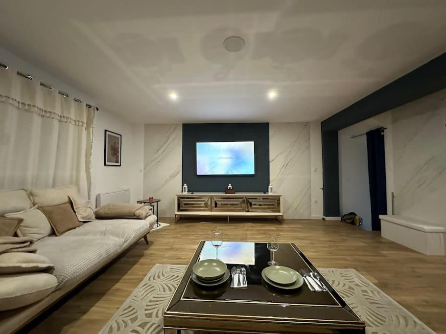 a living room with a couch and a flat screen tv at Sublime maison de 2 étages avec cour in Chilly-Mazarin