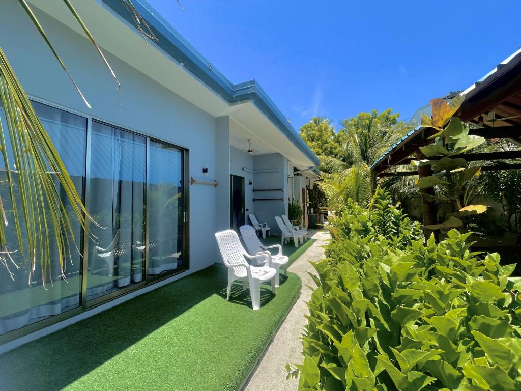 a patio with a white chair and some plants at La Solara Villa in Ukulhas