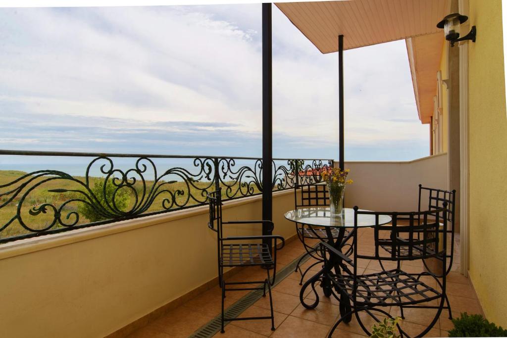 a balcony with chairs and a table and a view of the ocean at Complex Villas Kaliakra & Gradina in Bŭlgarevo