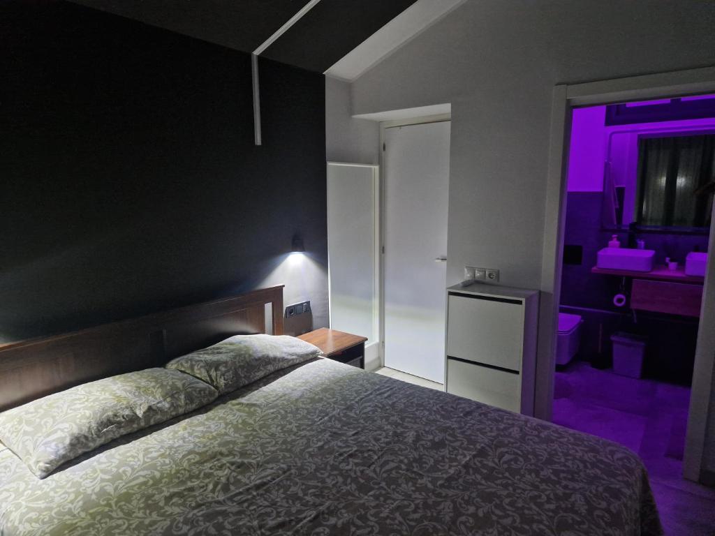 een slaapkamer met een bed en een paars licht bij Bungalow Eden Green Oasis in Maspalomas