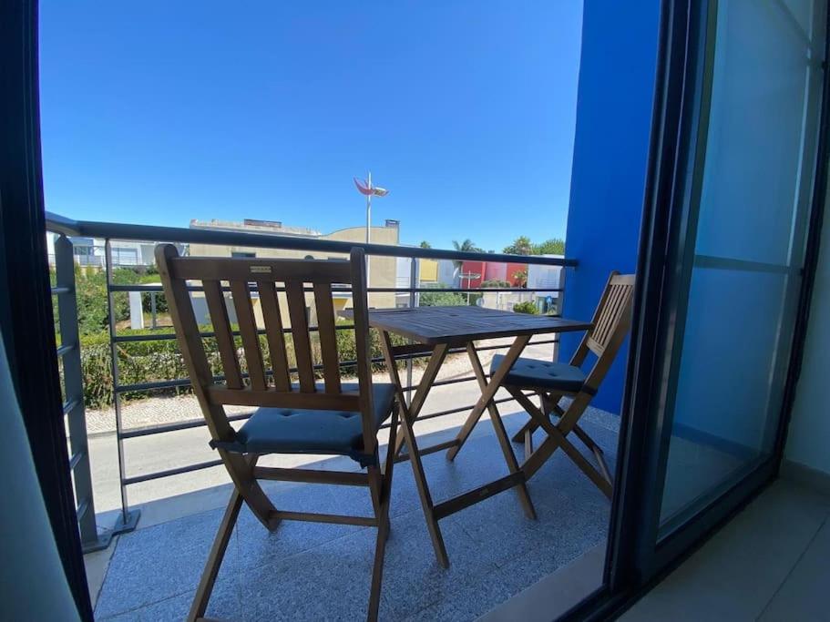 a table and a chair sitting on a balcony at Porta 28 in Quinta do Anjo