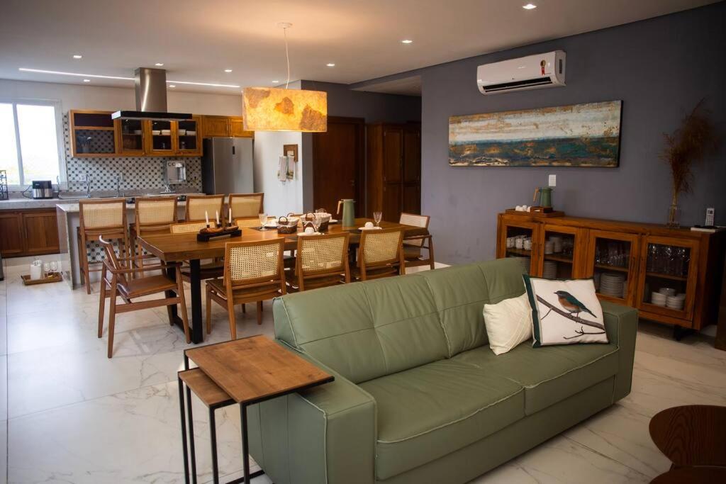 a living room with a green couch and a dining room at Casa em Tiradentes 14 pessoas in Tiradentes