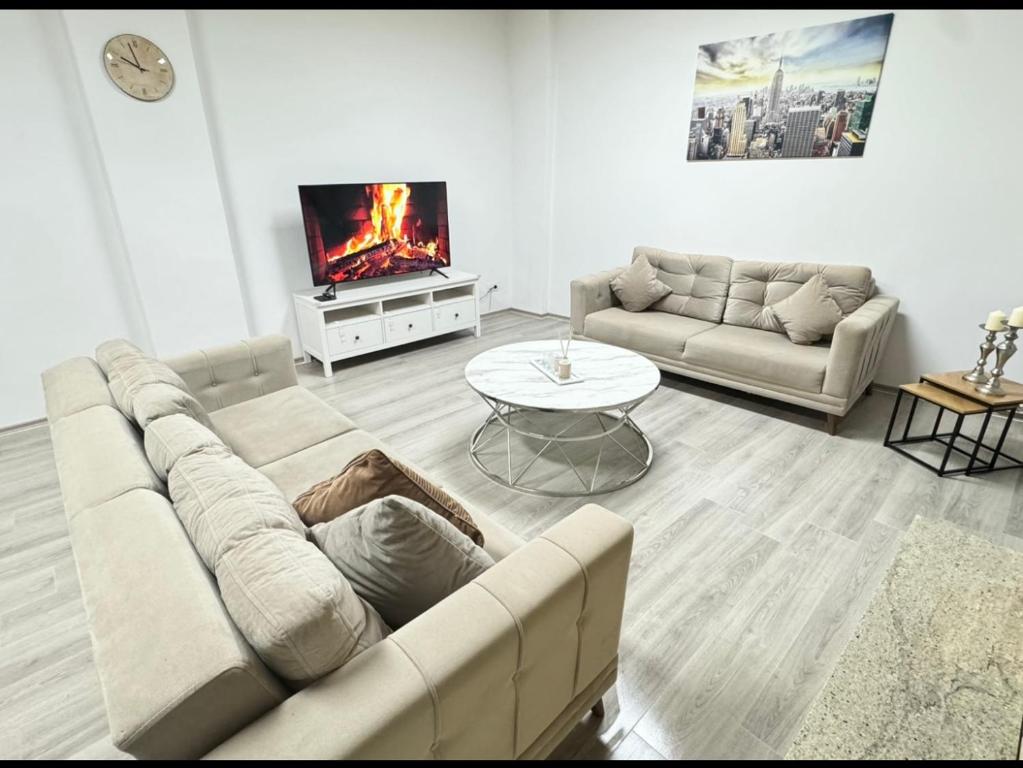 Una sala de estar con un sofá y un televisor. en Stylish & Relaxing Modernes Apartment mit Privatparkplatz, en Gelsenkirchen