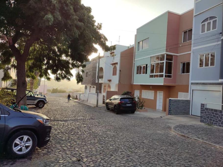 une rue avec des voitures garées sur le côté d'un bâtiment dans l'établissement Bela's house, à Mindelo