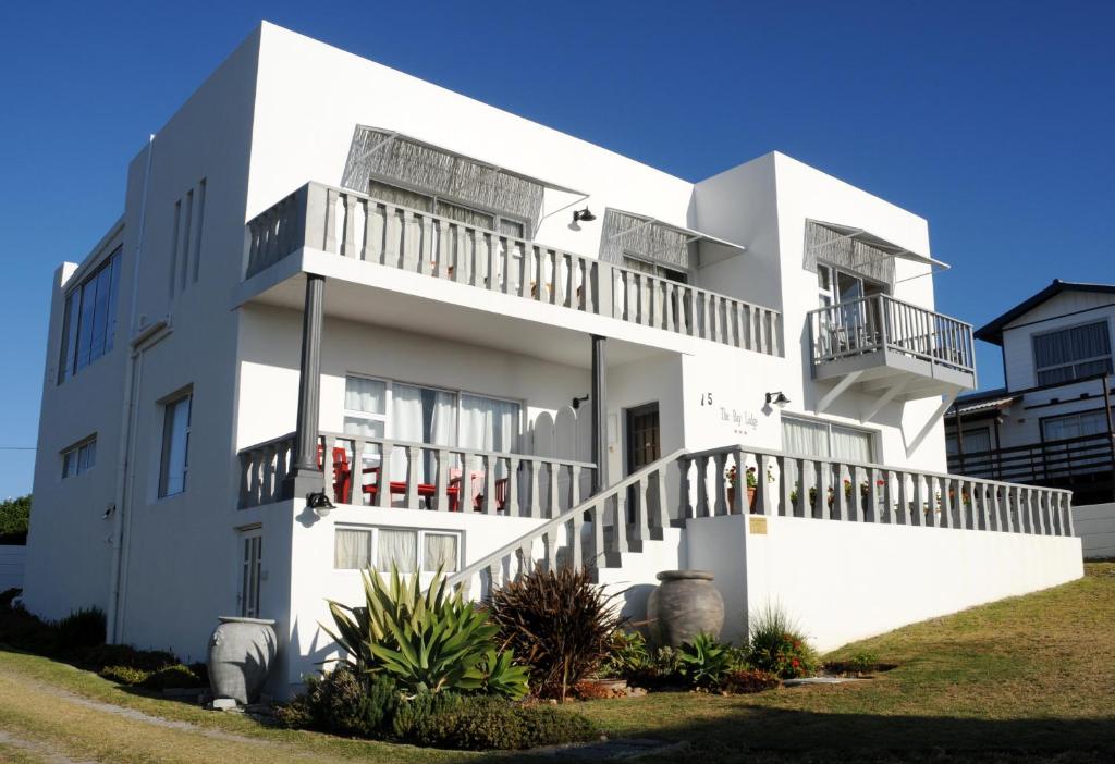 a white house with balconies on a hill at The Bay Lodge in Gansbaai