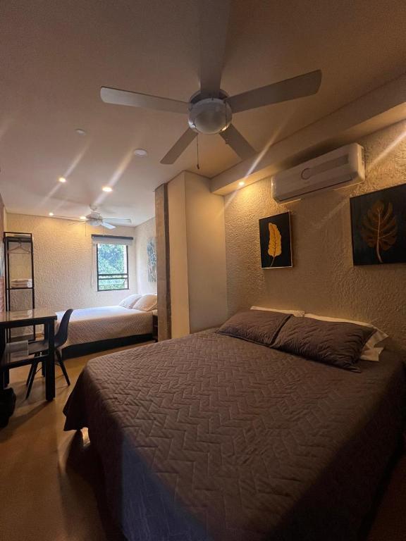 a bedroom with a bed and a ceiling fan at Bunde Haus Hotel EXPRESS BOUTIQUE in Ibagué