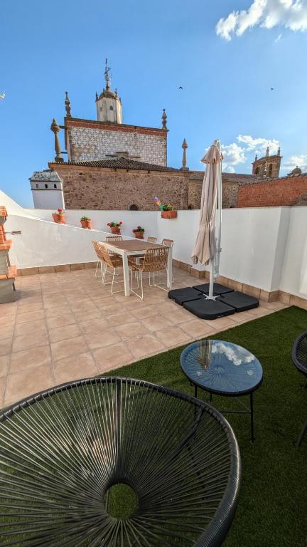 a patio with a table and chairs and an umbrella at Casa Carola in Trujillo