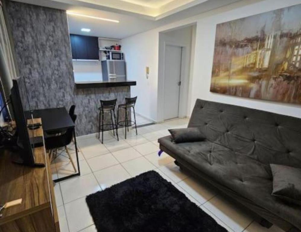 un salon avec un canapé et une cuisine dans l'établissement Apartamento Confortavel 2 quartos ao lado Shopping, à Uberlândia