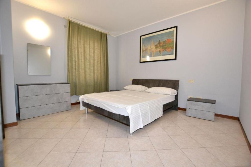 デセンツァーノ・デル・ガルダにあるAppartamento Capolaterraの白いベッドと鏡のある寝室