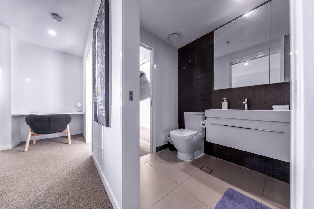 a bathroom with a white toilet and a sink at Modern APT in Toowong with Mountain View in Brisbane