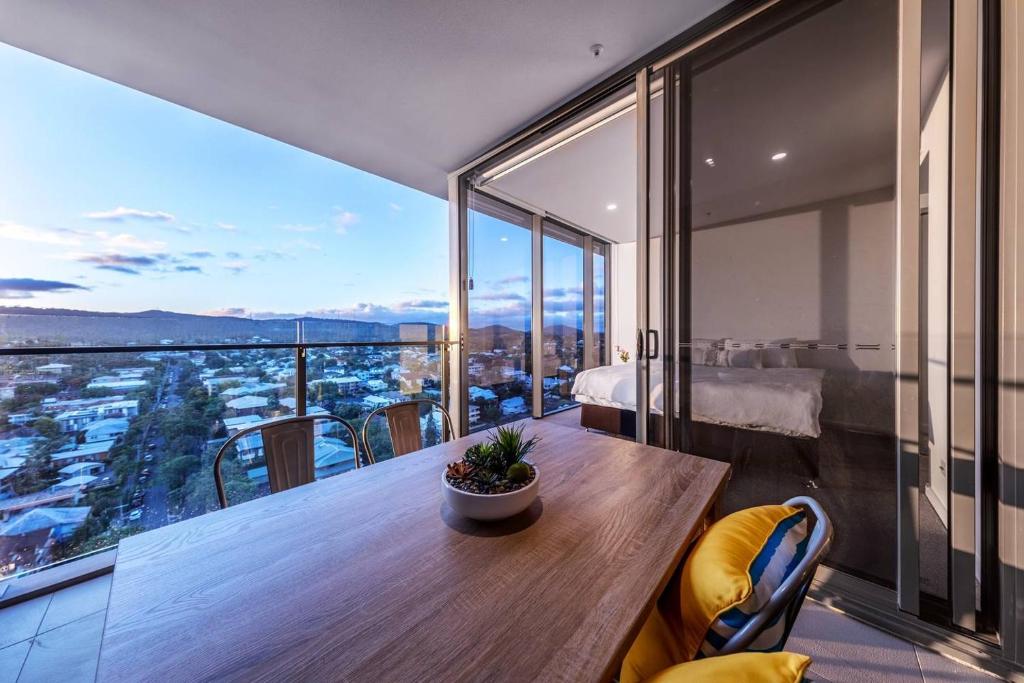 a room with a table and a balcony with a view at Modern APT in Toowong with Mountain View in Brisbane