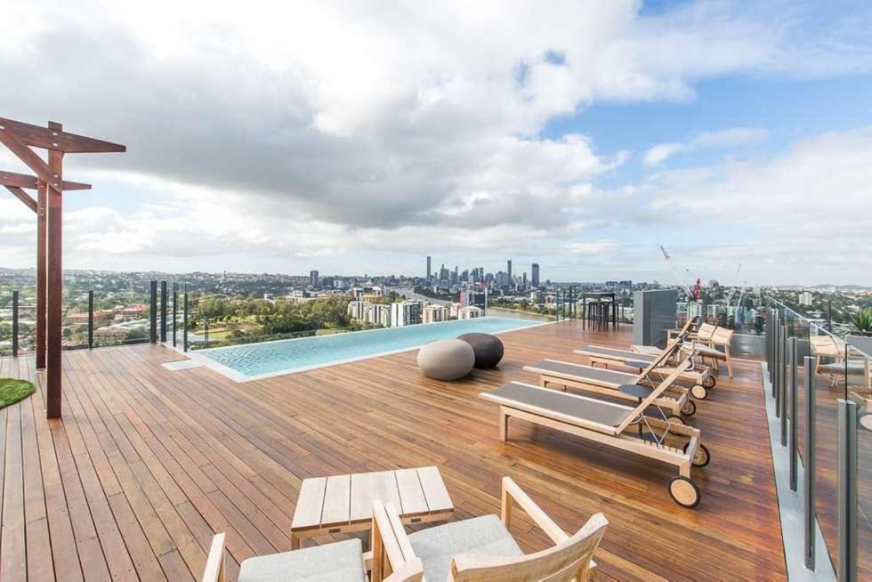 a rooftop deck with chairs and a swimming pool at Modern APT in Toowong with Mountain View in Brisbane