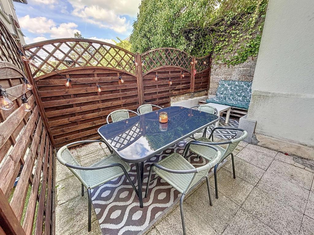 une table et des chaises bleues sur une terrasse dans l'établissement Appartement RDC près de la plage avec terrasse et Wi-Fi - FR-1-361-555, à Jullouville