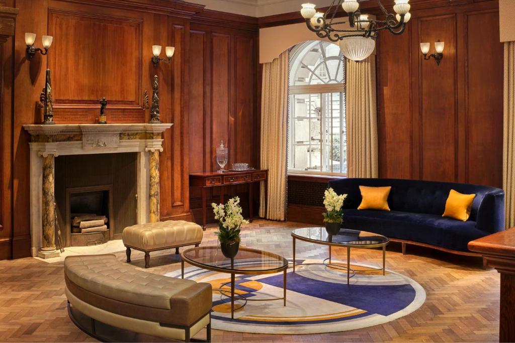 a living room with a blue couch and a fireplace at London Marriott Hotel County Hall in London