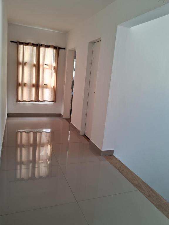 una stanza vuota con finestra e pavimento piastrellato di Smilesurf room a Rio de Janeiro