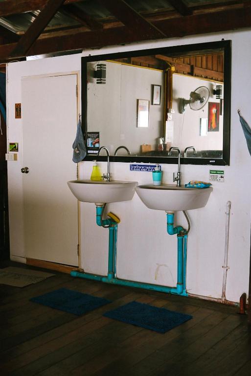 a bathroom with two sinks in front of a door at WaterMellow Hostel in Koh Tao