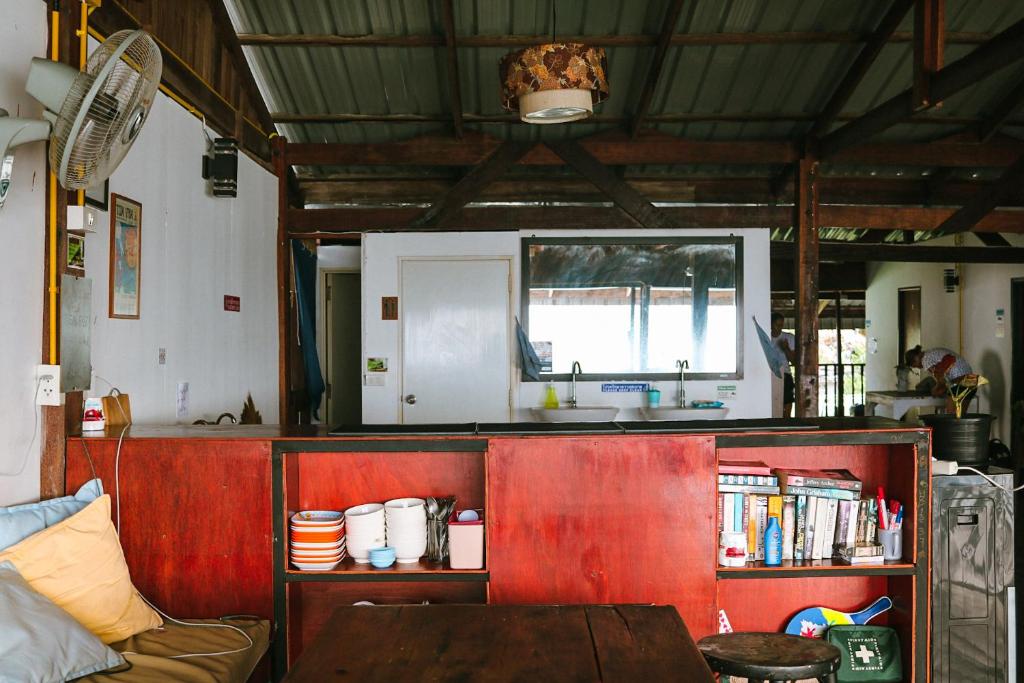 a kitchen with a counter with a sink and a table at WaterMellow Hostel in Koh Tao