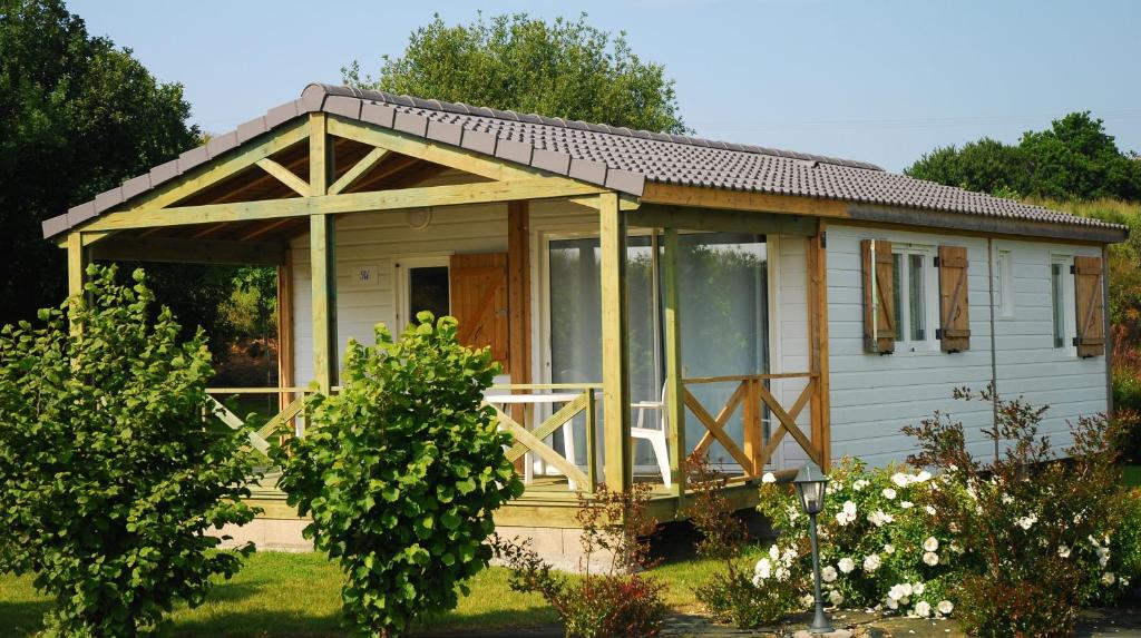 ein kleines weißes Cottage mit einem großen Fenster in der Unterkunft Les Cottages du Limonay in Saint-Méloir-des-Ondes