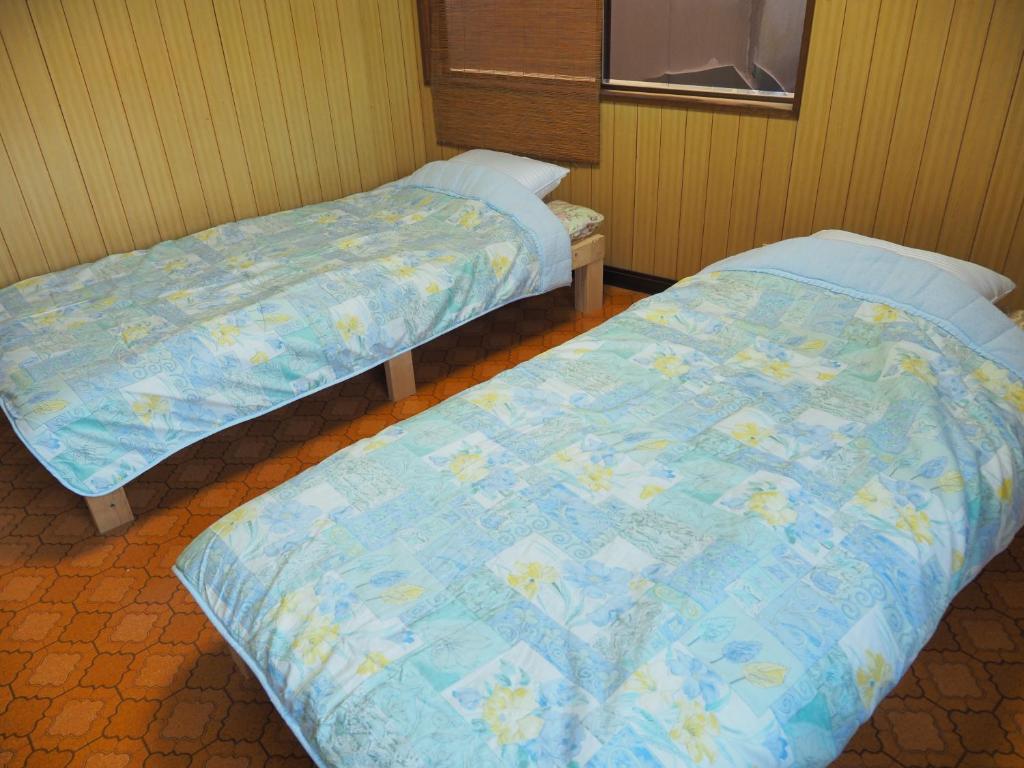Postel nebo postele na pokoji v ubytování ゲストハウス黒島