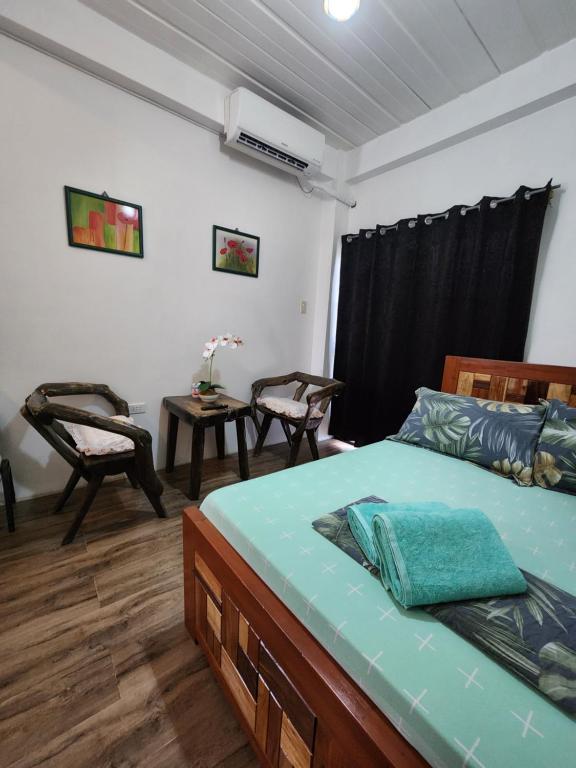 a bedroom with a bed and a table and chairs at ASHBURN'S TRANSIENT LA UNION - BAUANG, Self Service, Self Check-in, MOTORCYCLE Parking in Bauang
