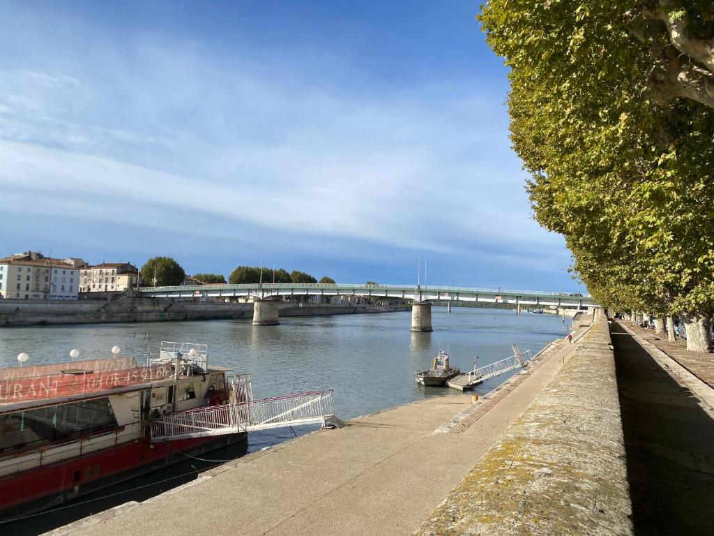 un bateau sur une rivière avec un pont en arrière-plan dans l'établissement Maison des Quais, à Arles