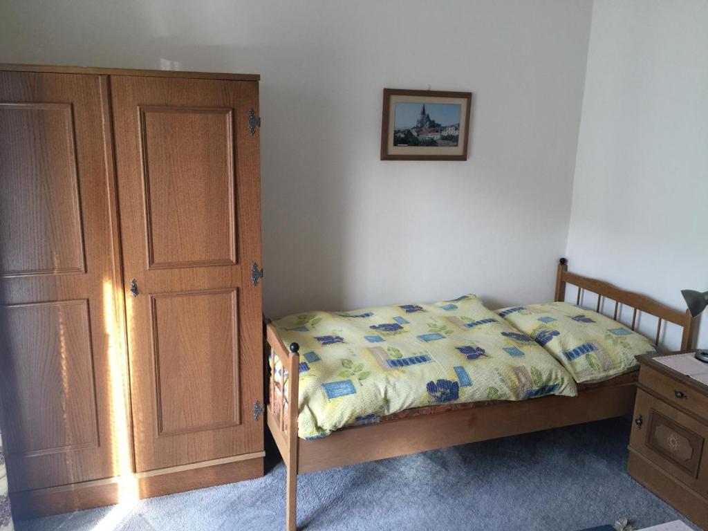 1 dormitorio con 1 cama y armario de madera en Landhaus Moises, en Bad Hofgastein