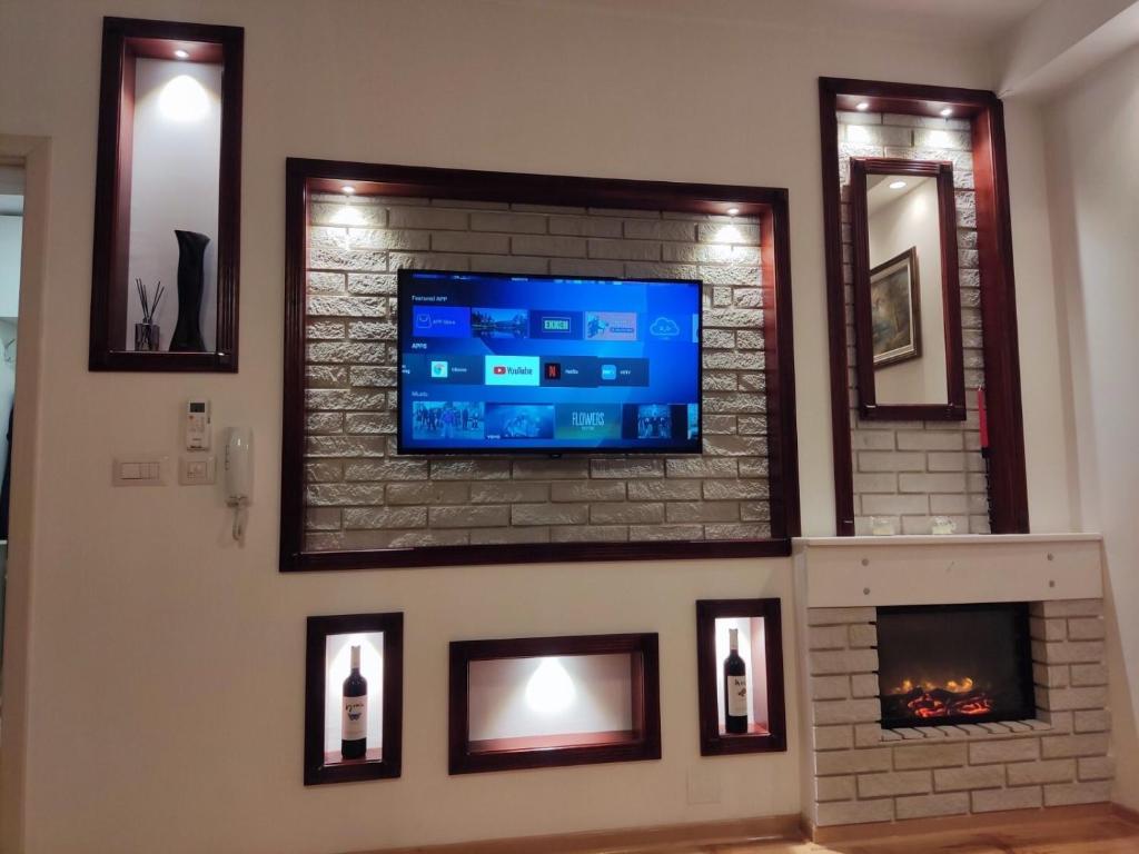 a living room with a tv on a brick fireplace at Apartmani Stanković in Vranje