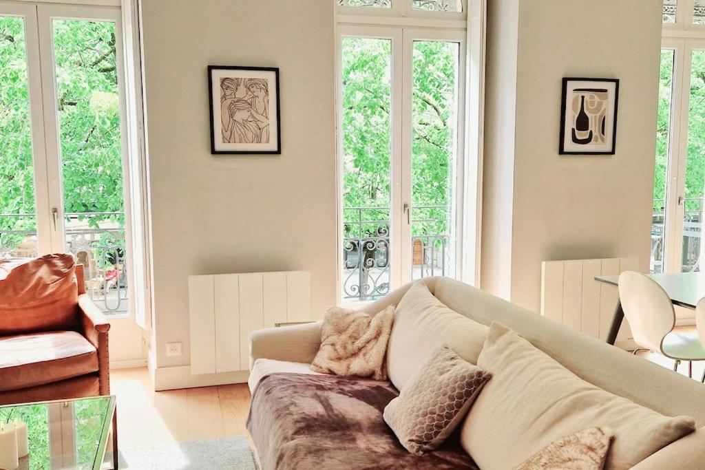 un salon avec un canapé et quelques fenêtres dans l'établissement Charmant appartement T3 plein centre, à Luchon