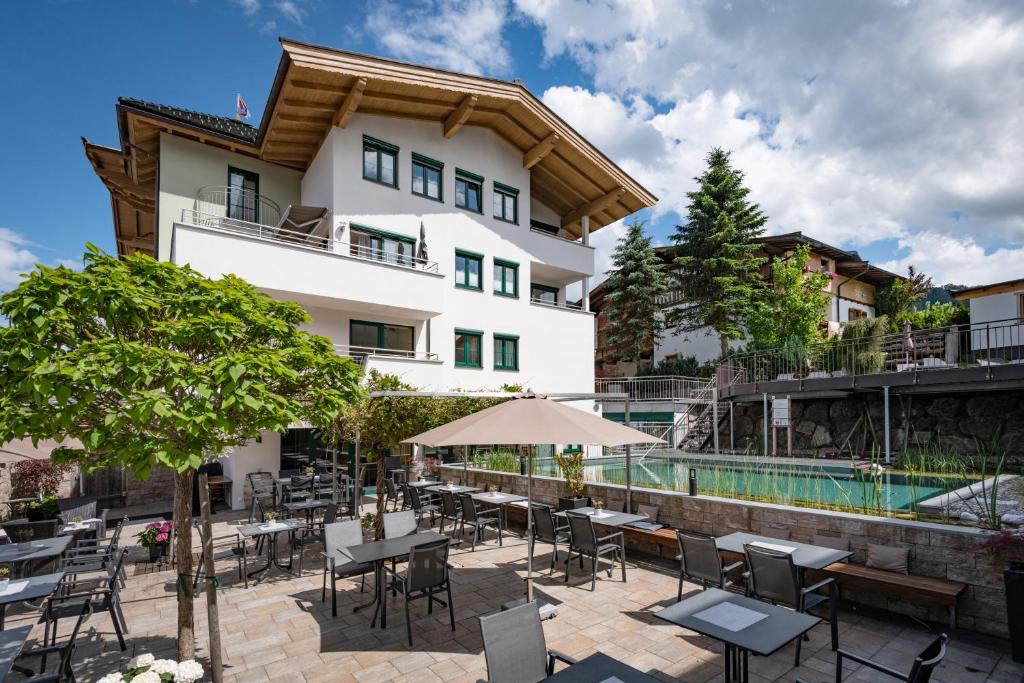 hotel z basenem, stołami i krzesłami w obiekcie Hotel Gänsleit w mieście Söll