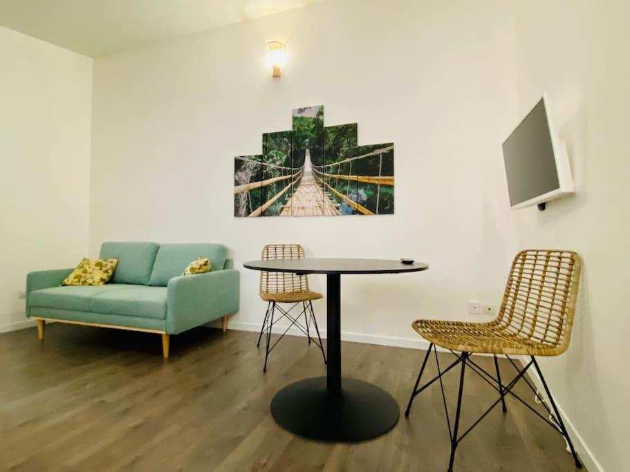 un salon avec un canapé, une table et des chaises dans l'établissement Le Bali, Magnifique T2, centre ville 1 er etage, à Valence