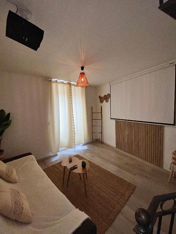 - un salon avec un canapé et un écran de projection dans l'établissement Maison de ville COSY, à Bourg-Saint-Andéol