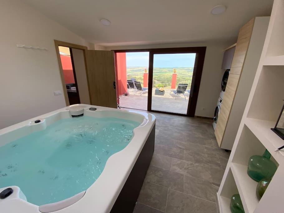a large bath tub in a bathroom with a view at Apartament2 Ca la Maru amb jacuzzi comunitari in Sant Antolí i Vilanova