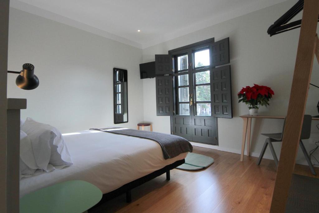 Un dormitorio con una cama grande y una ventana en H Complutum, en Alcalá de Henares