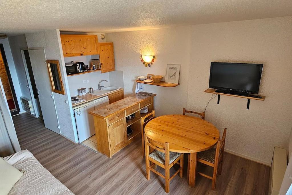une petite pièce avec une table et une cuisine dans l'établissement Un studio à Villard-Reculas, à Villard-Reculas